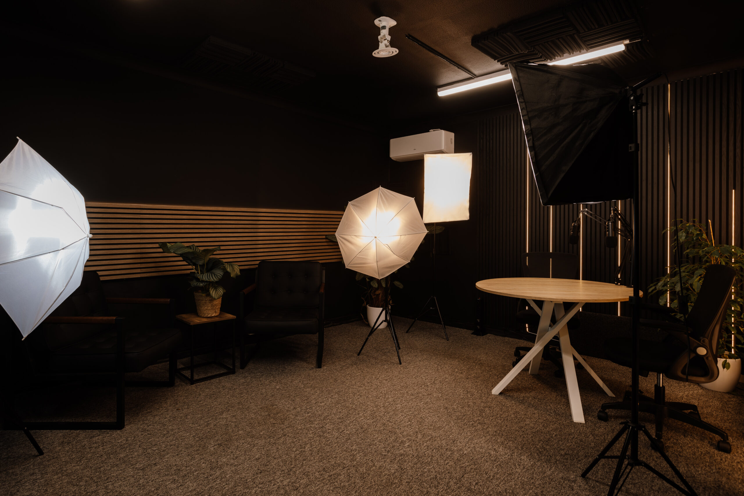 Professional podcast studio setup with multiple microphones and seating