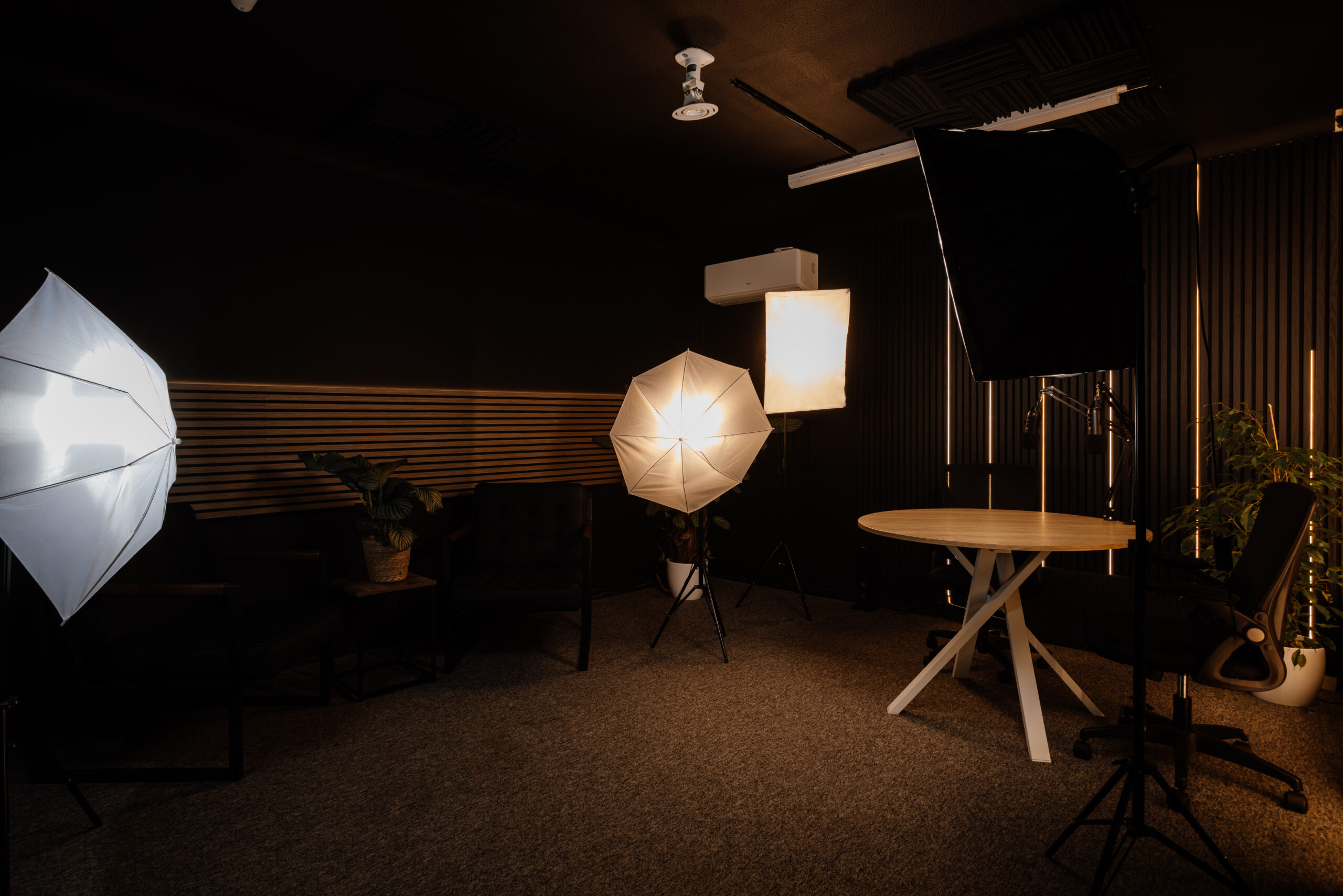 Podcast studio interior with chairs, microphones, and warm lighting