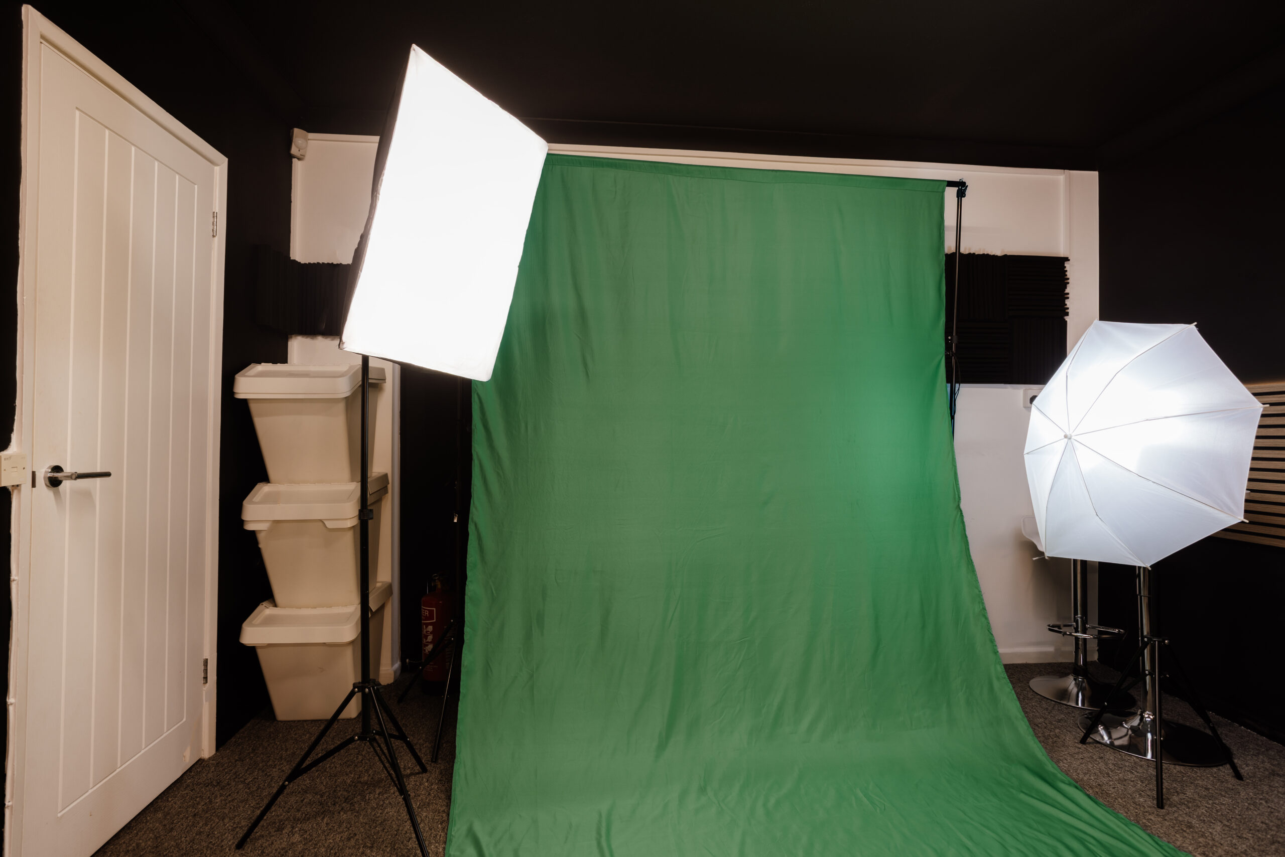 Wide view of the podcast studio with seating, microphones, and production lighting